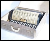 A vintage 20th century 1930s Hohner Carmen 2 piano accordion musical instrument in original case.