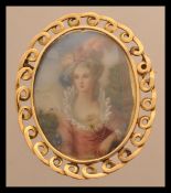 An 18ct gold brooch depicting a 19th century lady signed Paris. Weighs 11 grams.