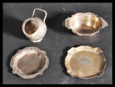 A group of silver items to include a continental silver table salt of mortar form with relief