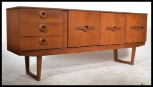 A retro teak wood Danish inspired sideboard circa 1970's having a series of cupboards and a bank