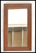 A 20th century oak framed mirror of rectangular form. Cushion shaped scalloped oak mirror frame with