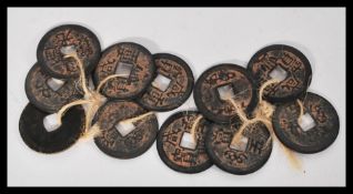 A group of antique Chinese coins , tokens with character marks and pierced centers.