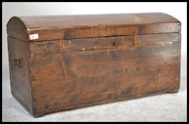 A large 19th century pitch pine dome-top rectangular trunk, icon carrying handles to sides