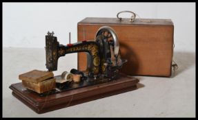 An early 20th century Singer Sewing machine complete in the original carry case of mahogany inlaid