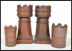 A pair of early 20th century stoneglazed chimney pots with wavey castle tops and ribbed borders on
