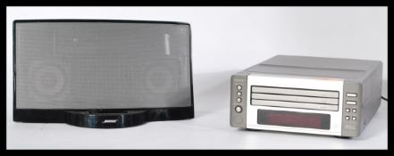 A 20th Century Denon Compact Disc player together with a Bose docking station speaker.