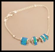 A sterling silver Tiffany style bracelet set with enamel and blue opal. Weighs 12 grams.