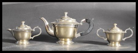An early 20th century silver plated three piece gents bachelors tea service having shaped scroll
