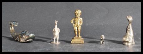 A pair of silver plated Maltese carp along with a figurine of a tiger and a llama and a Bruxelles