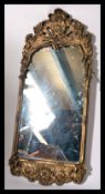 A mid century, circa 1950's rococo gilt wall mirror. The gilt frame with central rectangular wall
