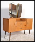 A 1960's retro oak drop centre dressing table being raised on tapering legs with a large mirror of