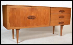 A 1970's retro teak wood sideboard being raised on tapering legs having a double door cupboard