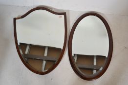 Two early 20th century wooden framed mirrors. On of oval form with boxwood inlay and the other of