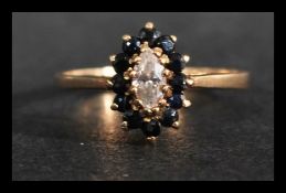 A hallmarked 9ct gold cluster ring having a central marquise cut white stone surrounded by