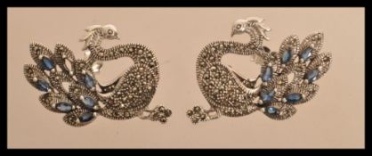 A pair of sterling silver marcasite earrings in the form of peacocks having sapphires to the