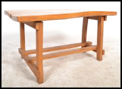 A retro mid 20th Century live edge elm topped coffee table raised on block supports united by twin