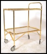 A vintage retro 20th Century gilt metal tubular two tier drinks trolley, raised on the original