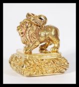 A brass cased fob seal having chased decoration with lion finial and bail loop atop.