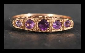 A hallmarked 9ct gold ring set with 5 amethyst in a gypsy setting. Hallmarked Birmingham. Size O.