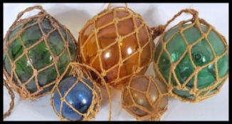 A collection of vintage 20th century coloured glass fishing buoys , coloured glass balls in rope