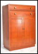 A 1930's Art Deco oak tallboy chest having twin cupboard doors with linen shelved interior with