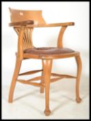 A vintage 20th century 1920's industrial oak office chair raised on pad feet with cabriole legs with