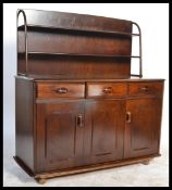 An Ercol style room divider sideboard with upright gallery back over shaped wide body on castors