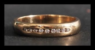 A hallmarked 9ct gold and diamond band ring having 9 suspension set diamonds. Hallmarked Birmingham.