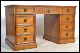 A good large antique style oak twin pedestal writing desk having tooled red leather writing