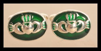 A pair of sterling silver Welsh Claddagh cuff links with green enamel panels. Weighs 9 grams.