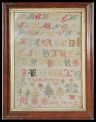 A 19th century Victorian tapestry sampler featuring the Alphabet with trees , birds and plants.