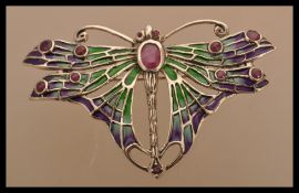 A sterling silver plique a jour brooch in the form of a butterfly having a ruby thorax. Weighs 9.8