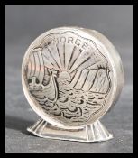 A Norway silver salt / pepperette of circular form with chased decoration of Viking longboats to