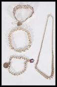 A group of silver bracelets to include a heart padlock example , heavy belcher link chain , fob