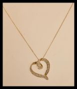 A hallmarked 9ct gold and white stone pendant in the form of a heart on 9ct gold necklace chain.