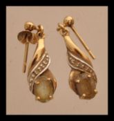 A pair of hallmarked 9ct gold ladies drop earrings having prong set topaz stones. Weighs 1.9 grams.