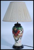 Moorcroft pottery table lamp, baluster-shaped with tube-lined decoration of various flowers together