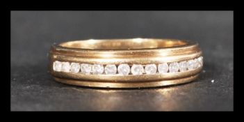 A hallmarked 9ct gold and diamond half eternity ring having 15 diamonds in a suspension setting.