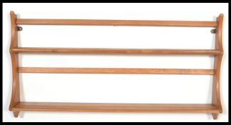 A vintage retro 20th century Ercol Golden Dawn hanging shelves of graduating form with makers