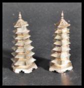 A pair of early 20th century Chinese silver pepperettes in the form of pagoda buildings. The seven