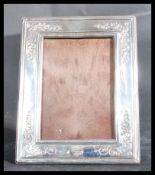 A 20th century silver hallmarked easel backed picture frame of rectangular form having embossed