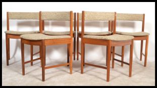 A set of 20th century Danish influenced teak wood dining chairs. Raised on turned legs united by