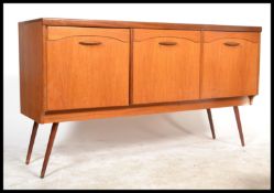 A 1970's retro teak wood long john sideboard comprising  a series of 3 cupboards with shaped handles