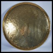 A 19th century Indian brass charger of roundel form with a gallery edge being impressed and chased