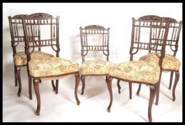A set of four early 20th Century Edwardian mahogany dining chairs, over stuffed seat pads with