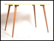 A vintage mid 20th Century dining table having a stunning yellow formica top raised on tapering