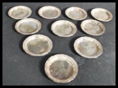 A matching set of ten continental silver peanut dishes / pin trays of scalloped form each being