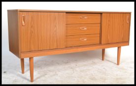 A retro 20th Century teak effect sideboard having a central bank of three drawers flanked by sliding
