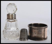 A group of hallmarked silver items to include a napkin ring , thimble and a collared cut glass