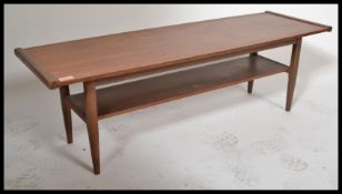 A retro 20th Century teak wood surfboard style coffee table raised on shaped supports with a solid